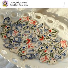 a white plate topped with lots of blue and red decorated cookies on top of a table