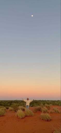 a person standing in the middle of a desert with their arms wide open and hands up