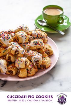 a pink plate topped with cookies and sprinkles next to a cup of coffee