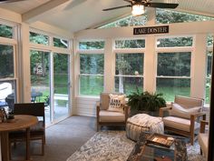 a sun room with couches and chairs in it