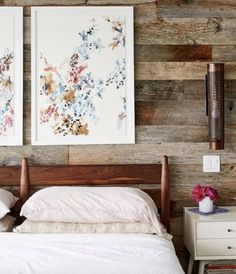 two paintings hang on the wall above a bed