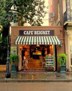 a cafe with awnings and tables outside on the side of the street in front of some buildings