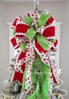 a christmas tree decorated with green and red ribbons, bows and polka dot bow for the top