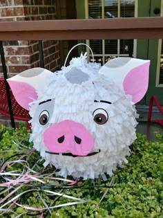 a pig made out of toilet paper sitting in the grass