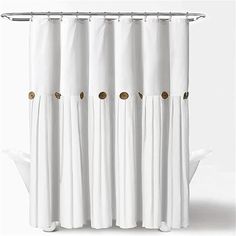 a white shower curtain with gold buttons on the top and bottom, in front of a white background