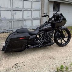 a black motorcycle parked in front of a garage