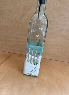 a glass bottle with sand and seaweed in it