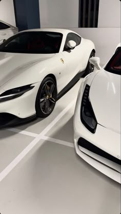 two white sports cars parked next to each other