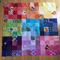 a colorful patchwork quilt sitting on top of a wooden floor