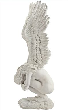 a statue of an angel kneeling down with its wings spread