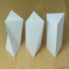 three white boxes sitting on top of a wooden table