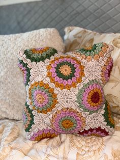 a crocheted pillow sitting on top of a bed