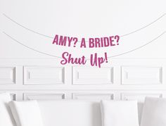 a white couch sitting next to a wall with the words, why am i? a bride shut up