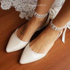 a woman wearing white high heels on top of a wooden floor