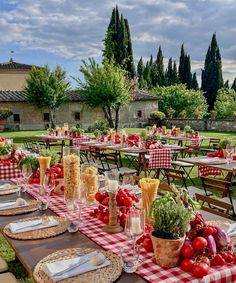 an outdoor dining area with tables and chairs covered in red checkered tablecloths