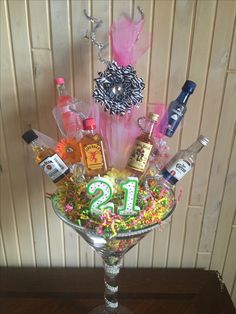 a glass vase filled with liquor bottles and confetti