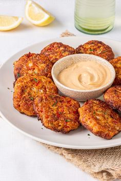 crab cakes on a plate with dipping sauce