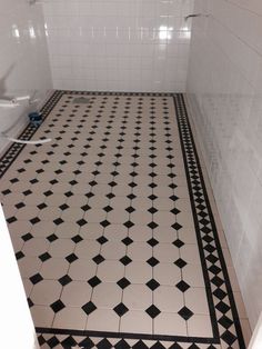 a bathroom with black and white tile flooring next to a toilet in the corner