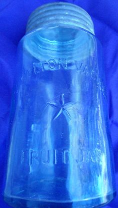 a blue glass jar sitting on top of a blue cloth