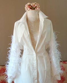 "This white shirt with ostrich feathers can be paired with your favorite bell-bottom jeans, a wide belt, or a high-top boot. It features an oversized cut, Dress Shirt Women, pleated waist, lapel collar, long puff sleeves, buttoned cuffs, and a curved hem. Every time you wear, You will be fascinated by the fluttering sleeves of the feathers. until everyone is jealous.🌷 Size: One Size fits most - 49.4\" Bust. fits most - 35\" Waist. fits most - 49.2\" Hip. Length: 34.6\" Component 20% Cotton 80% Long Sleeve Feather Top For Fall, Long Sleeve Feathered Tops For Fall, Spring Long Sleeve Tops With Feathers, Dress Shirt Women, Feather Shirt, Genderless Fashion, Embellished Shirt, Feather Tops, Spandex Shirts