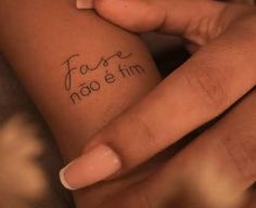 two hands holding each other with writing on their fingers and the words fosse nao e tim written in cursive ink