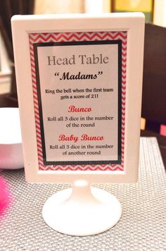 there is a sign on the table that says head table madam's and it has pink pom poms