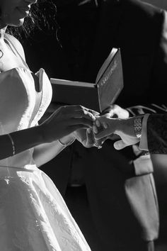 black and white photograph of a woman in a wedding dress holding an open ring box