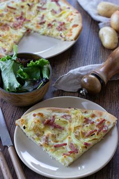 a slice of pizza on a plate next to a salad