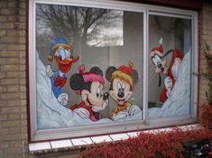 two mickey mouses and donald ducky on the outside of a window