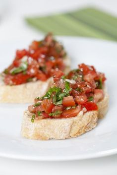 two pieces of bread topped with tomatoes and basil