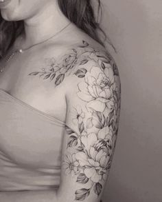 a woman with a flower tattoo on her arm and shoulder is posing for the camera