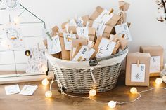 a basket filled with lots of brown paper and small tags on top of a wooden table