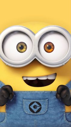 a close up of a minion wearing overalls and looking at the camera with eyes wide open