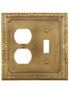 an antique style switch plate with two outlet covers in gold metal and ornate designs on the front