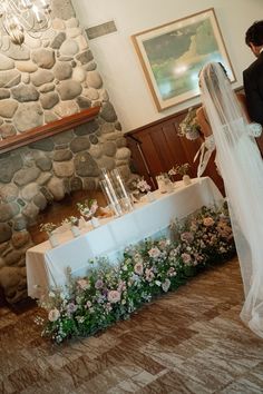 a bride and groom standing in front of a table