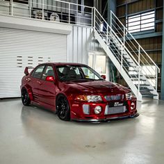 a red sports car parked in front of a staircase