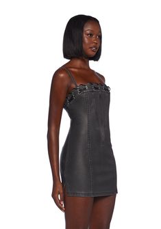 This fully lined mini dress has a matte vegan leather construction, structured boning on the front and back, side slits, a lace-up design at the neckline, adjustable shoulder straps, and a back zipper closure. Black Mini Dress With Spaghetti Straps And Strap Detailing, Fitted Black Mini Dress With Strap Detailing, Black Mini Dress With Spaghetti Straps, Gothic Spaghetti Strap Mini Dress For Night Out, Gothic Mini Dress With Spaghetti Straps For Night Out, Chic Mini Dress With Strap Detailing For Night Out, Gothic Mini Dress With Straps, Edgy Mini Dress With Back Zipper For Night Out, Mini Corset Dress With Straps For Night Out