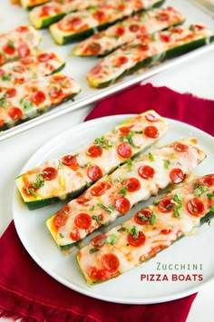 zucchini with tomatoes and cheese on a white plate next to a red table cloth