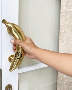 a person is holding a banana shaped door handle