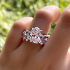 a close up of a person's hand holding an engagement ring