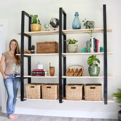 a woman standing in front of a book shelf with baskets and books on the shelves