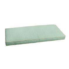 a green pillow sitting on top of a white floor