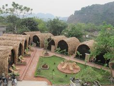 an outdoor area with grass huts and trees