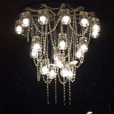 a chandelier hanging from the ceiling in a dark room with lights on it