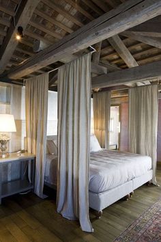 a bed sitting under a wooden ceiling in a bedroom