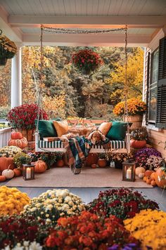 a porch covered in lots of pumpkins and flowers