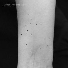 a black and white photo of a wrist with small stars on the left side of it