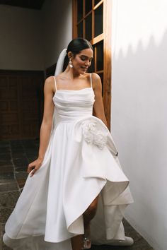 a woman in a white wedding dress is walking down the stairs with her shoes on