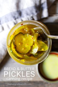 a jar filled with pickles next to a cup of liquid