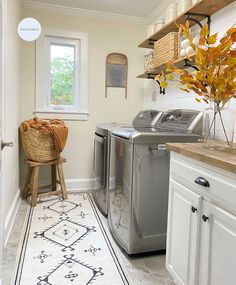 a washer and dryer sitting in a kitchen next to a counter with a basket on it